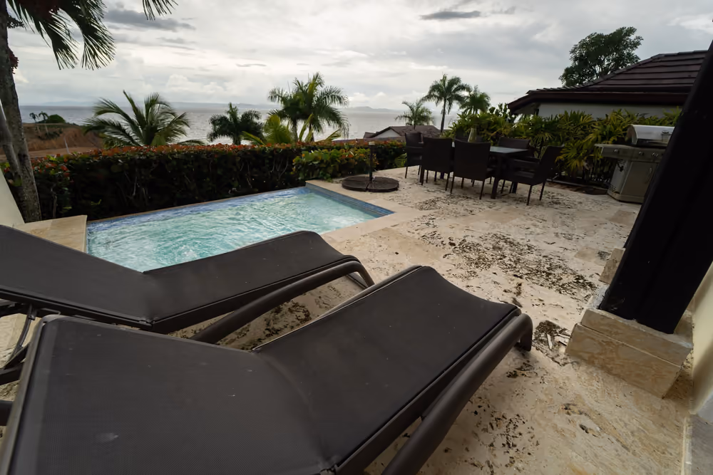 Piscina privada con tumbonas y la bahía de Samaná al fondo