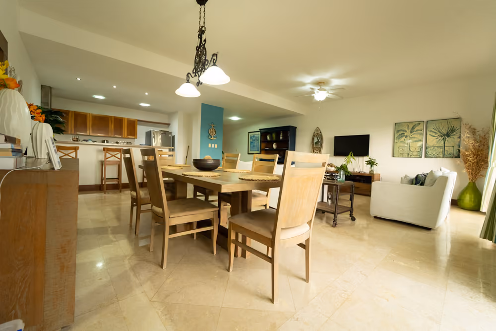 Comedor de madera para seis personas junto a la cocina abierta