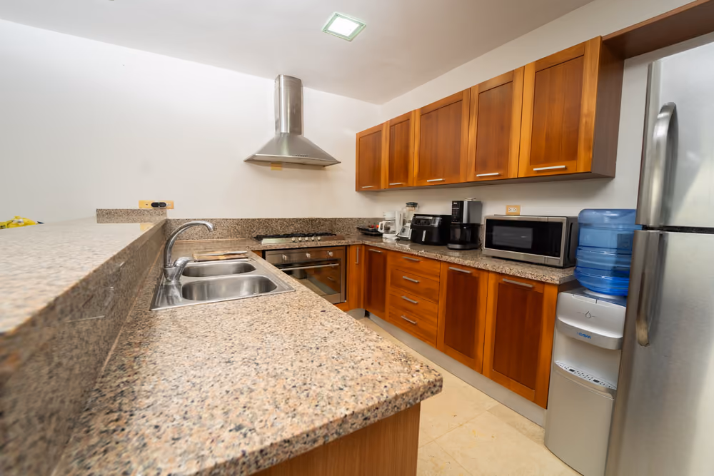 Cocina equipada con encimeras de granito, estufa de gas, horno y microondas