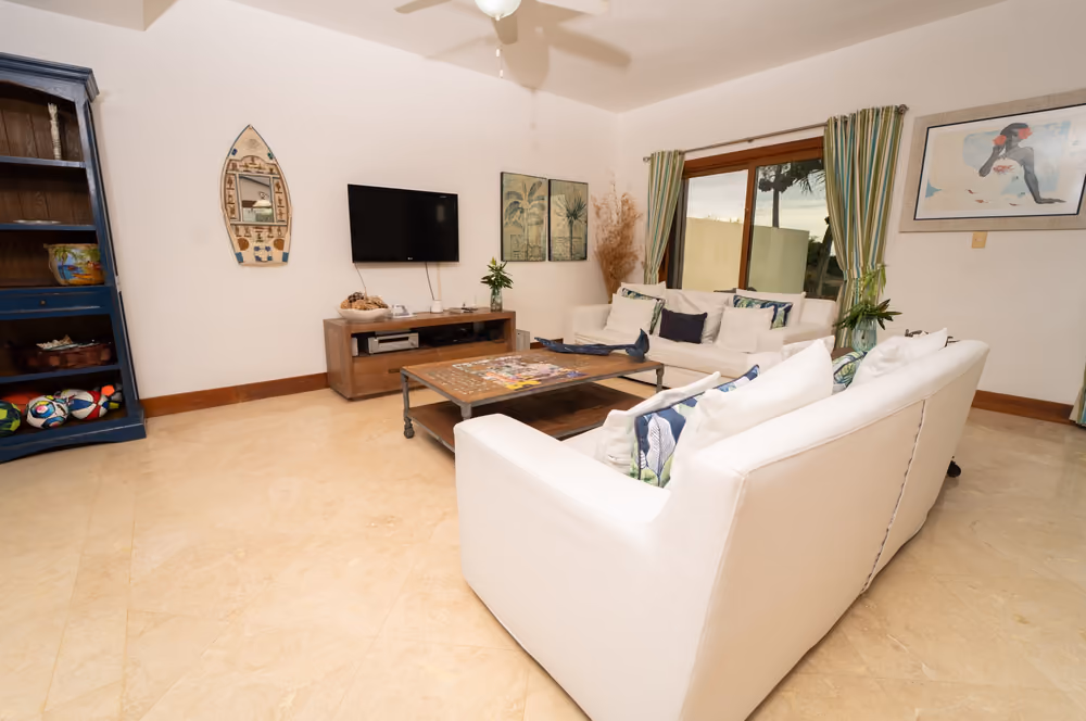 Sala familiar con televisor y librero en la planta baja